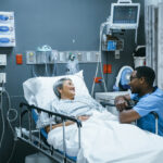 Nurse talking to patient in hospital bed