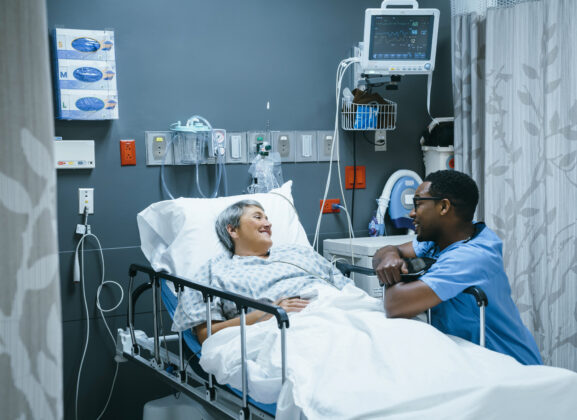 Nurse talking to patient in hospital bed